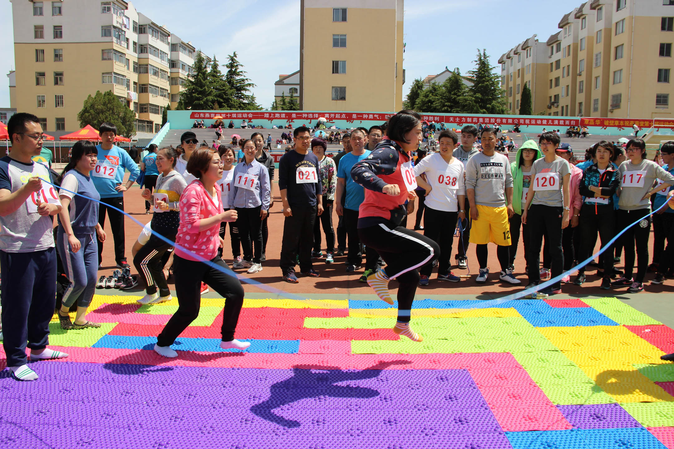 参赛队员在指压板上跳长绳,2人摇绳,其余6人列队分别从绳的一侧跳至另